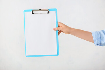 Woman with blank clipboard on white background