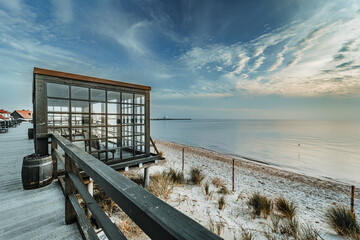 A beautiful shot of a glass viewing room on a wooden pier at a beach in Hel Town, Poland