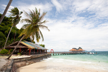 Sand beach with palm trees and bungalow