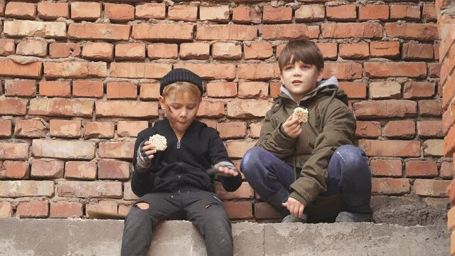 Poor street kids enjoy meal on street, eating donationa food. Social issues, poverty problem concept.