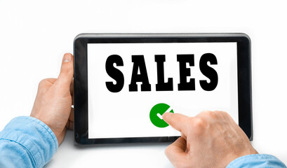 Closeup of a male hands holding tablet pc with word Sales