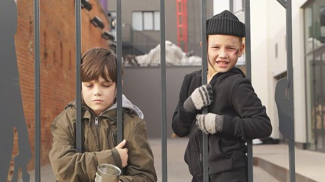 Two poor street boys need help asking help food donation from strangers, on street at big city, begging. Shelter concept.