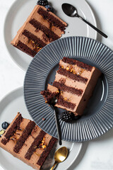 Pieces of chocolate cake with berries on gray plate, white marble background, top view. Vegan dessert concept.