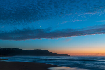 Fototapeta premium High cloud, partial moon and a pretty blue dawn at the beach