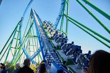 Belek, Turkey - December 17, 2019: Roller coaster Ride against blue sky in a nice day and people in...