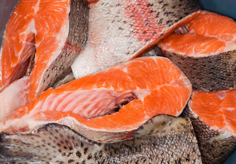 Background of uncooked rainbow trout pieces, top view close-up