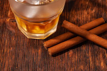 One glass of whisky and cigar on wooden table