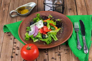 Greek salad with juicy tomatoes, feta cheese, lettuce, green olives, cucumber, red onion and fresh parsley. Homemade food. Symbolic image. Concept for a tasty and healthy vegetarian meal. Close up.
