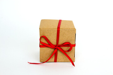 Gift box with red ribbon isolated on white. The concept of gifts for the holidays. Christmas and New Year. Cardboard box decorated with a red ribbon.