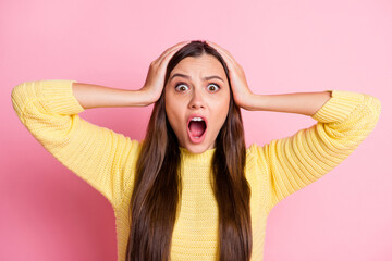 Portrait of young attractive shocked surprised scared afraid girl hold hands head open mouth isolated on pink color background