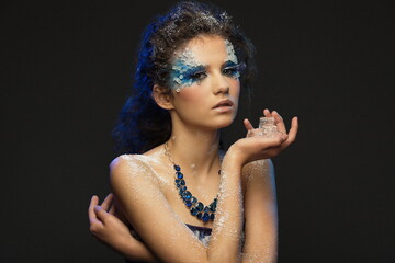 Obraz premium portrait of a beautiful girl with a fantasy winter makeup with ice pieces in her hands