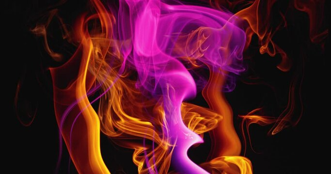 Surreal slow dance of clouds of colored smoke. Swirls of fabulous smoke on a dark background. Abstract colored tongues of flame. Slow motion.