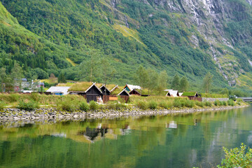 Fototapeta na wymiar Gudvangen, Norway - a viking houses with grass-covered roofs. Traditional wooden houses showing the medieval life in the viking village. 