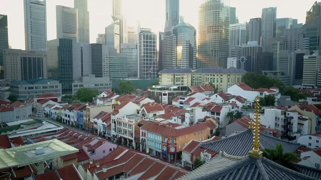 Drone footage of old buildings against tall skyscrapers in the city Singapore
