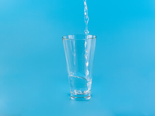 Glass with water aqua on blue background