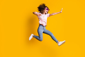 Fototapeta na wymiar Photo portrait full body view of woman kicking jumping up isolated on vivid yellow colored background