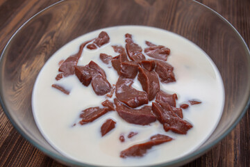 Beef liver soaked in milk in a glass bowl. Recipe