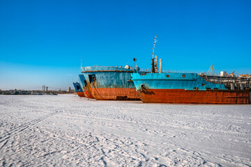 Togliatti, Russia - 25 Dec 2020: Ship repair plant, old abandoned ships for oil extraction in winter snowy landscape, frozen river