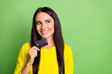 Portrait of adorable person debit card touch chin look empty space thinking isolated on green color background