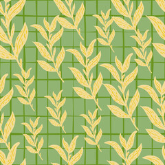 Random seamless pattern with pale yellow leaf branches ornament on green chequered background.
