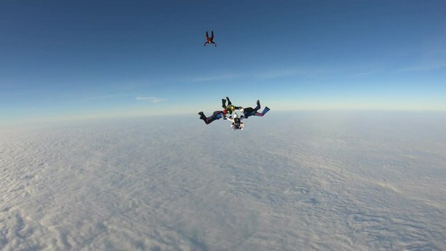 Skydiving. Team jump. Skydivers are doing figures in the sky.