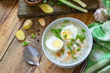 Hot soup chicken with ginger rice and garlic in a bowl on a rustic table. Top view flat lay.