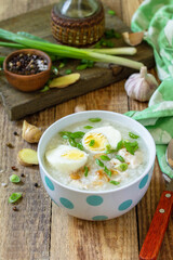 Hot soup chicken with ginger rice and garlic in a bowl on a rustic table. Copy space.