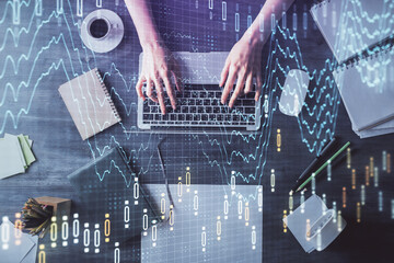 Multi exposure of woman hands working on computer and forex chart hologram drawing. Top View. Financial analysis concept.