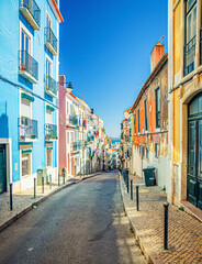Fototapeta na wymiar Typical narrow street with colorful multicolored traditional buildings and houses in Lisbon Lisboa historical city centre, Portugal.