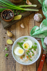 Hot soup chicken with ginger rice and garlic in a bowl on a rustic table.