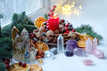 Fototapeta na wymiar Gemstones crystals, candle and natural winter decor. Witchcraft Ritual, energy healing minerals. Esoteric, relax, life balance concept. Christmas, Magical Winter Solstice