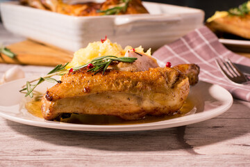 Roasted chicken leg with mashed potatoes on a white plate
