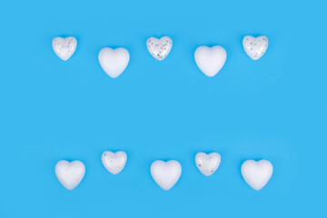 Minimal composition with white hearts on pastel blue background. Valentines day concept.