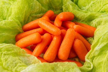 Small peeled pieces of baby carrot on green gauze cloth