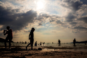 Silhouettes of people playing in the sea at a public beach