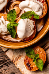 Delicious grilled peaches served with whipped cream and mint leaves. Grilled peaches, apricots, nectarines and ice cream