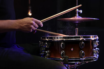 Drummer playing snare drum with sticks close up.