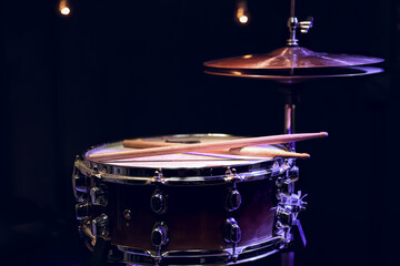 Close up shot of drumsticks lie on a snare drum.