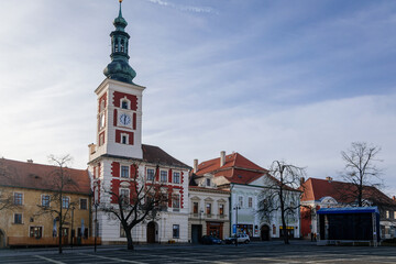 Old Town Hall with Clock Tower at the main Masaryk square of historic medieval royal town Slany, colorful renaissance houses in sunny winter day, Central Bohemia, Czech Republic