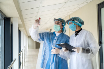 Naklejka premium Work in the clinic. Healthcare workers with test tubes with blood record the result of the test