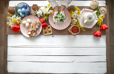 Top view festive table with Easter cake, flowers and tea for Easter.