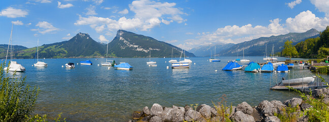 beautiful tourist resort Faulensee, moored sailboats and bathing area, lake Thunersee switzerland