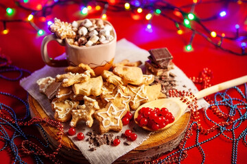 Christmas gingerbread cookies, a cup of hot chocolate in the back.