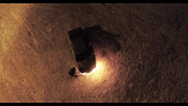 A man sets fire to a car. Winter. Night. The view from the top.