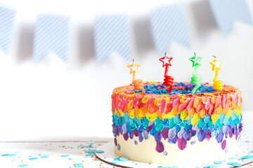 Handmade colorful big birthday cake with stars shaped candles.