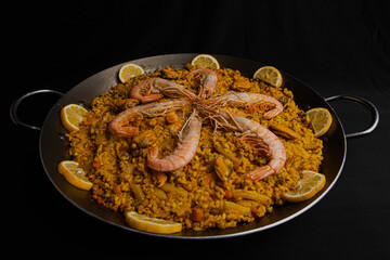 A typical Spanish Paella dish decorated with prawns and lemon. Made according to a traditional...