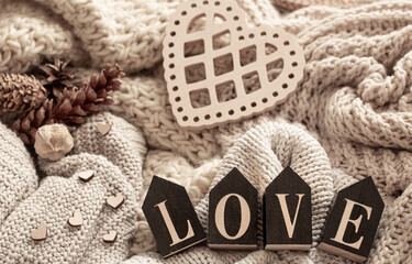 Cozy composition with knitted elements and wooden decorative word love.