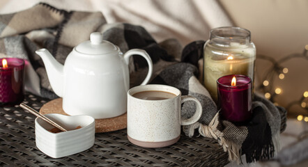 Cozy home composition with a cup of coffee and candles.