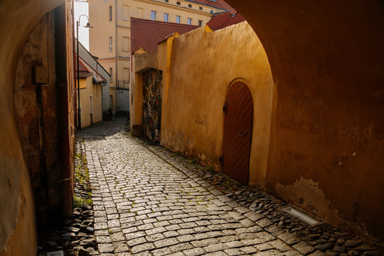 Narrow passageway, arched passage, picturesque street with colorful buildings in historic center, renaissance and gothic house, medieval city Slany, Central Bohemia, Czech Republic