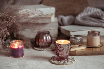 Composition of beautiful vintage candlesticks with burning candles on a blurred background.